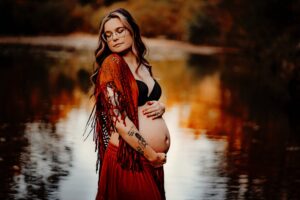 Mother to be poses for her maternity photos in a creek in Sandy Creek in Hillsboro Missouri