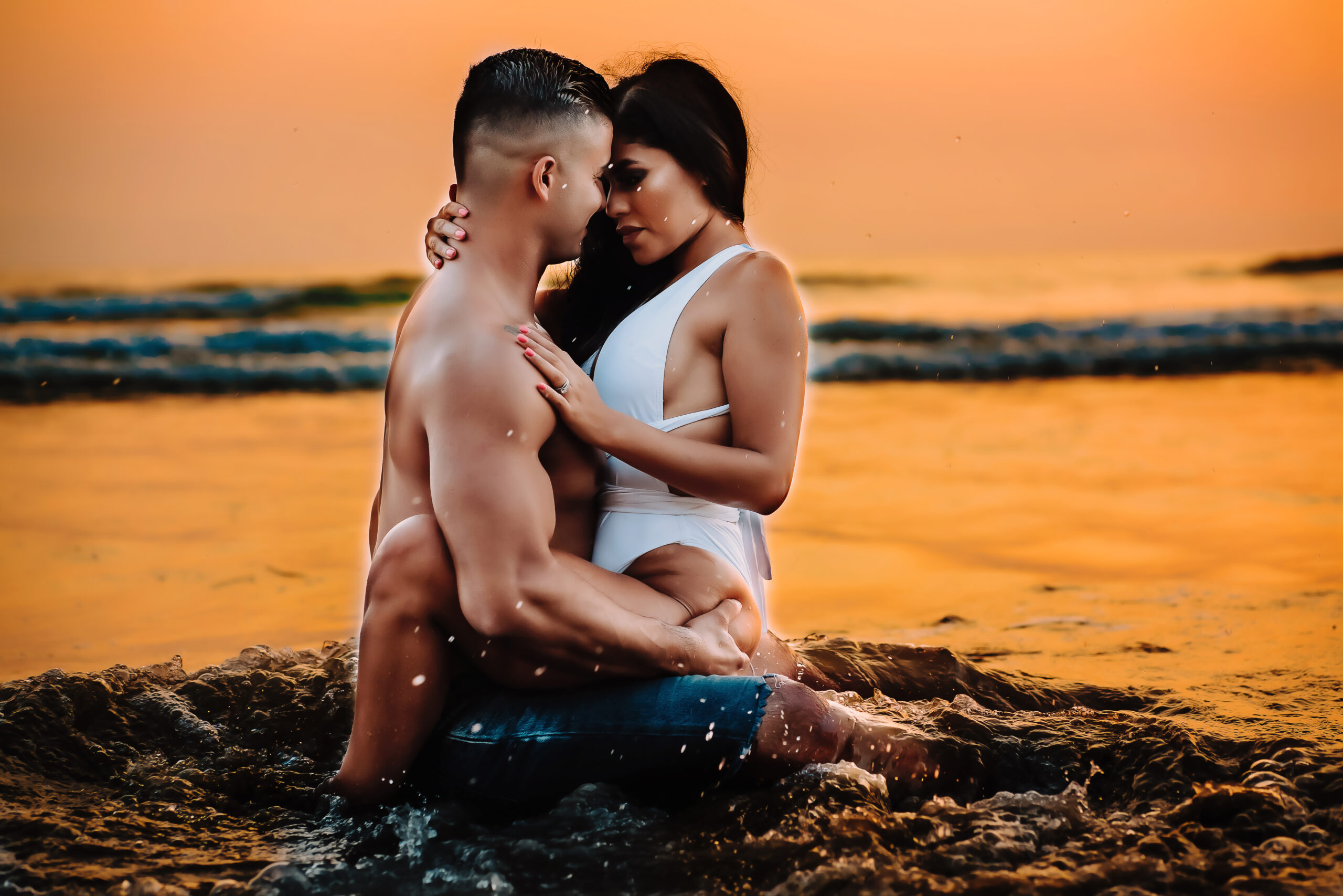 A man and woman embrace each other in the crashing waves, captured by St. Louis Boudoir Photographer Andrea Moore.