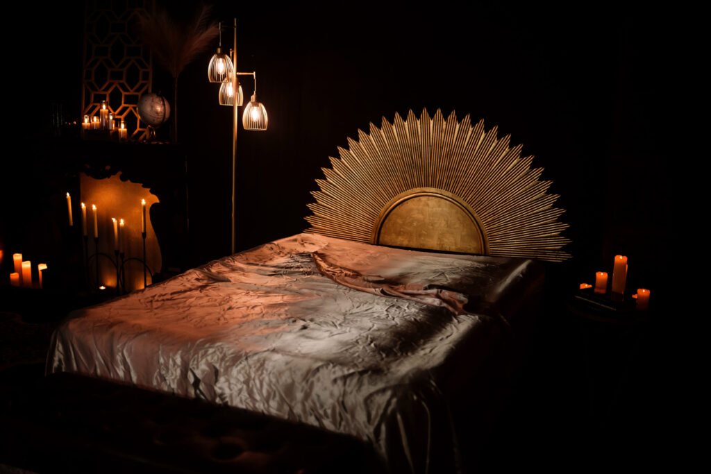 A gold sun sits behind a bed of silk sheets.